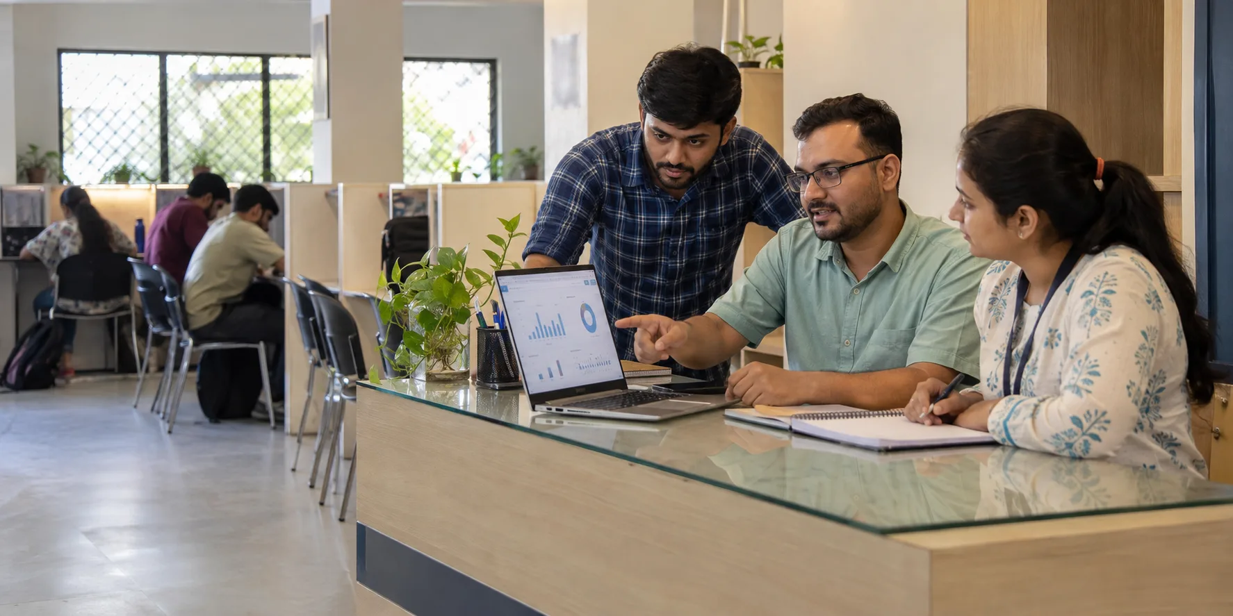 Indian study-library owner and staff reviewing daily business records at reception
