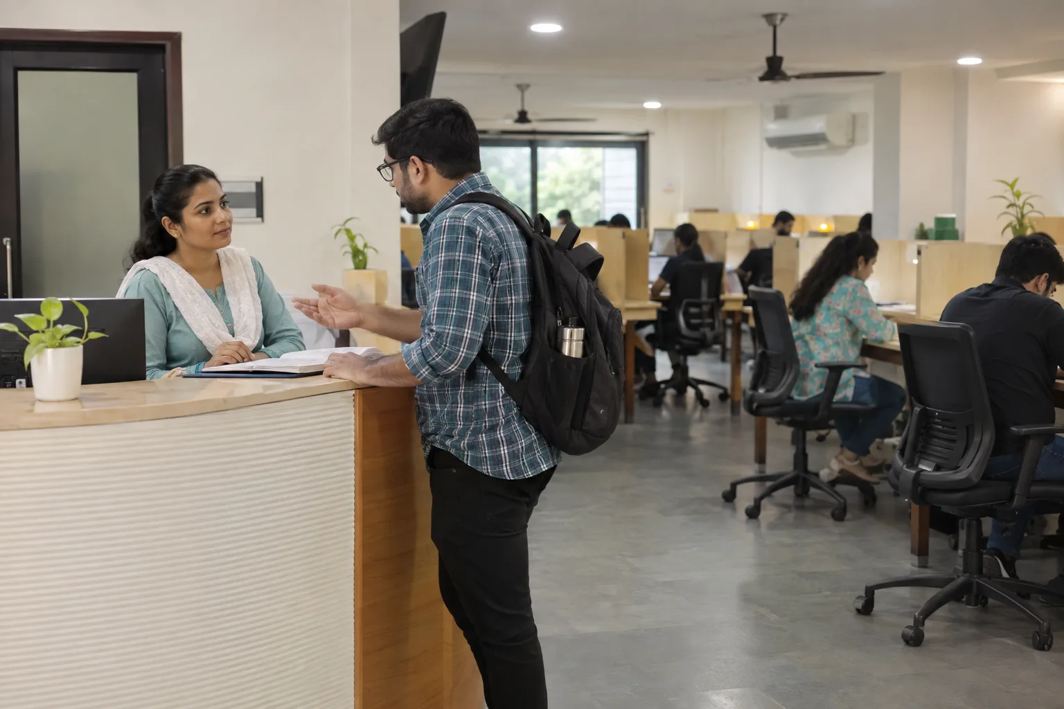 Indian study-library staff member speaking with an adult member about a service concern