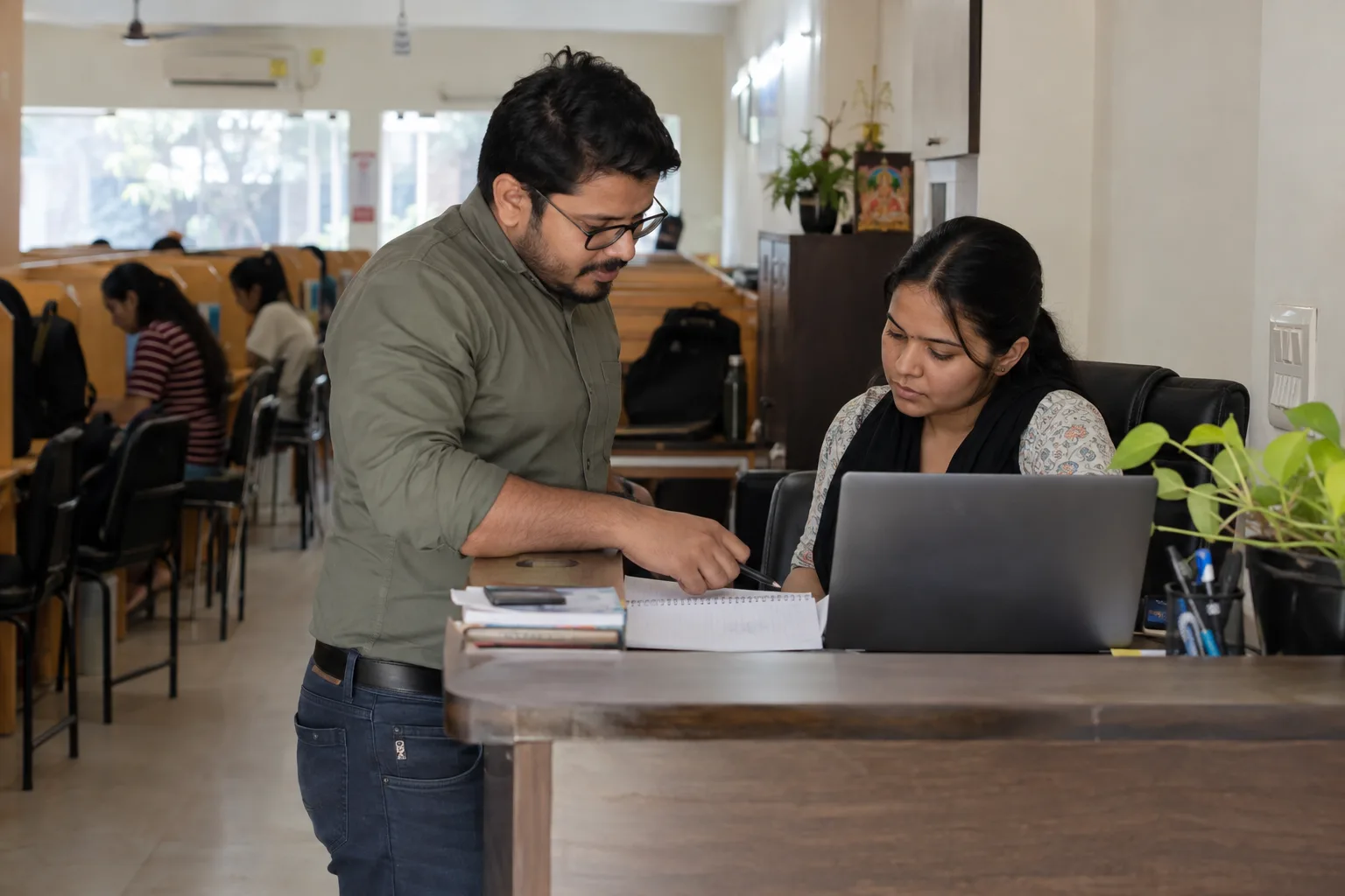 Indian study-library owner and staff discussing an operational report